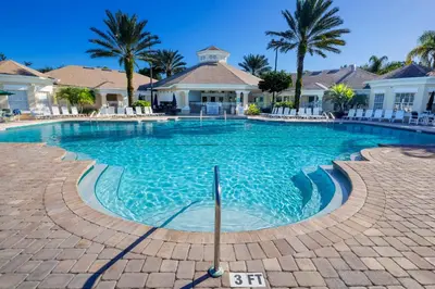 a swimming pool at a resort with palm trees at The Great Escape - A spacious 1st floor condo on Windsor Palms Resort - close to Disney in Kissimmee