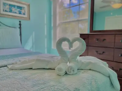 two towels in the shape of a heart on a bed at Beautiful, cozy and spacious Retreat near Disney in Kissimmee