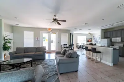 a living room with couches and a table and a kitchen at 1192SBC South Beach Villa in Kissimmee