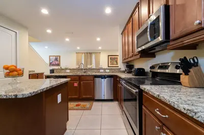 a large kitchen with wooden cabinets and granite counter tops at 360LD Encore Magic Villa in Orlando