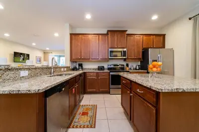 a large kitchen with wooden cabinets and granite counter tops at 360LD Encore Magic Villa in Orlando