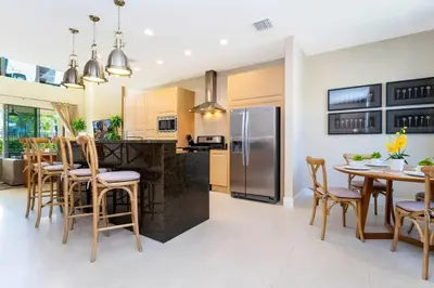 a kitchen with a table and chairs and a refrigerator at Marvelous 4 Bd Close to Disney @ Magic Village 3153 in Orlando