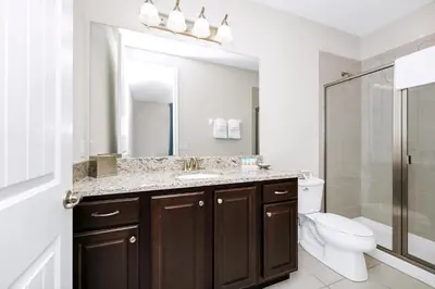 a bathroom with a sink and a toilet and a mirror at Spectacular Home Near Disney With Private Pool And Waterpark & Resort Access At Encore Resorts Reunion - 465Sf in Kissimmee