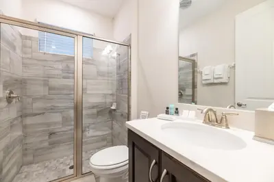a bathroom with a shower and a toilet and a sink at Chic Home With Private Pool, Game Room And Waterpark & Resort Access Near Disney At Encore Resorts Reunion - 320Au in Kissimmee