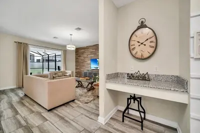 a living room with a clock on the wall and a couch at Gorgeous, Modern Home wPrivate Pool in Kissimmee