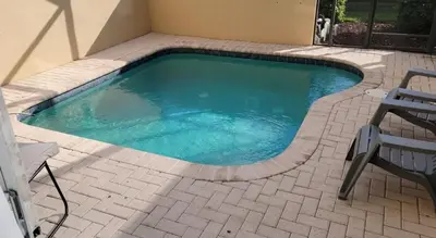 a small swimming pool in a patio with two chairs at 3 BR 2 Miles to Disney, pool, free WiFi and more townhouse in Orlando