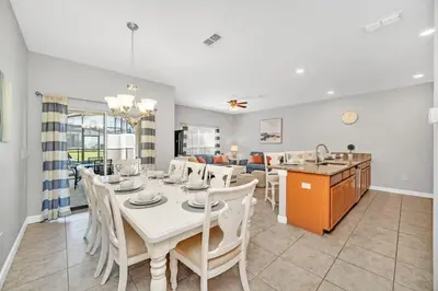 a dining room with a white table and chairs at In the heart of Kissimmee Storey Lake Resort 4BD 3BA Pool Townhome 4SL4857 in Kissimmee