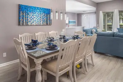a dining table and chairs in a living room at Spacious 4BR Home Themed Rooms, Pool, Near Disney in Orlando