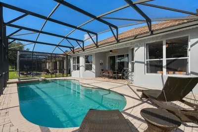 a swimming pool with chairs and a house at Luxury 5BR Villa Near Disney, Private Pool & Game Room in Orlando