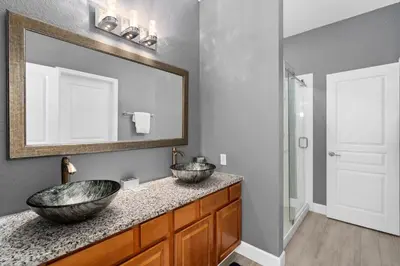 a bathroom with two sinks and a mirror at Luxury 5BR Villa Near Disney, Private Pool & Game Room in Orlando