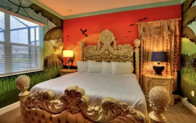 a bedroom with a large bed in a room with plants at NEW! 14BR Disney-Area Resort with Bowling & Theater in Kissimmee