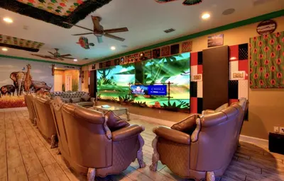 a waiting room with leather chairs and a video screen at NEW! 14BR Disney-Area Resort with Bowling & Theater in Kissimmee