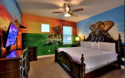 a bedroom with a bed with a painting on the wall at NEW! 14BR Disney-Area Resort with Bowling & Theater in Kissimmee