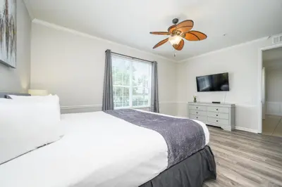 a white bedroom with a bed and a ceiling fan at Epic Universe 4 Bedroom Plus, Lake View Condo, Vista Cay-1008 in Orlando