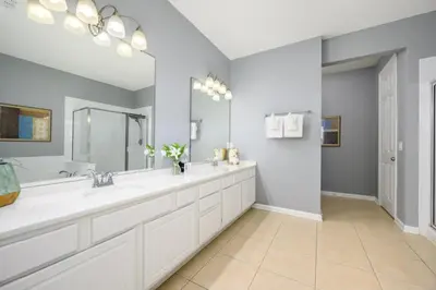 a bathroom with two sinks and a large mirror at Newly Renovated Premium Condo, Vista Cay - 2002 in Orlando