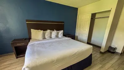 a bedroom with a large bed and a blue wall at Motel 6 Altamonte Springs FL in Orlando