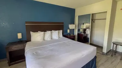 a bedroom with a large bed with white sheets and pillows at Motel 6 Altamonte Springs FL in Orlando