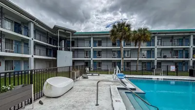 a large apartment building with a swimming pool in front of it at Motel 6 Altamonte Springs FL in Orlando
