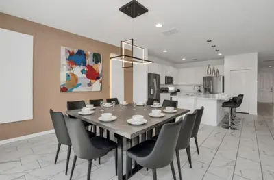 a dining room and kitchen with a table and chairs at American Secret 10 BED 7 Miles to Disney in Kissimmee
