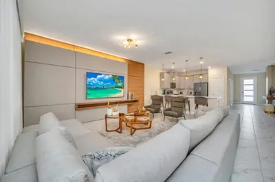 a living room with a large couch and a kitchen at Storey Lake 9 BR Villa With Games Room and Theater home in Kissimmee