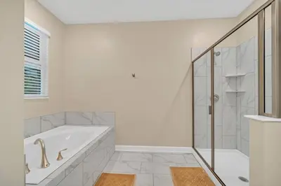 a white bathroom with a tub and a shower at Storey Lake 9 BR Villa With Games Room and Theater home in Kissimmee
