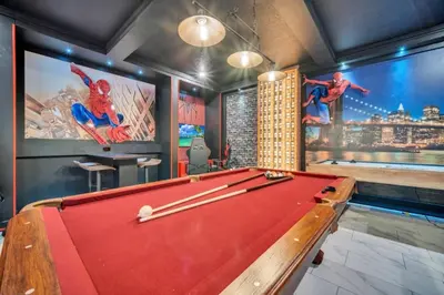 a billiard room with a pool table and a pool at Storey Lake 9 BR Villa With Games Room and Theater home in Kissimmee