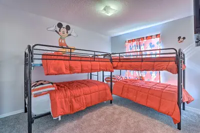 a bedroom with two bunk beds with orange sheets at Less Than 8 Mi to Disney Getaway with Deck in Kissimmee! in Kissimmee