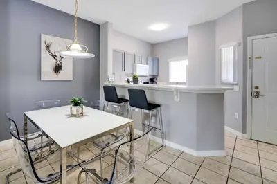 a kitchen and dining room with a white table and chairs at Kissimmee Escape about 10 Mi to Disney World! in Kissimmee