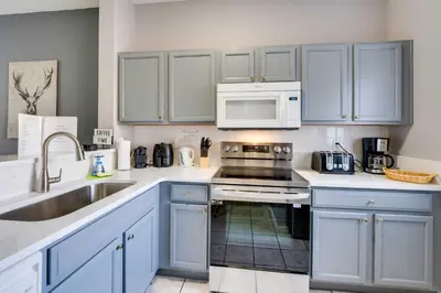 a kitchen with blue cabinets and a sink at Kissimmee Escape about 10 Mi to Disney World! in Kissimmee