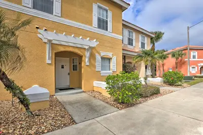a yellow house with a white door on a street at Kissimmee Escape about 10 Mi to Disney World! in Kissimmee