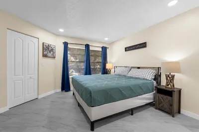 a bedroom with a bed with blue curtains and a window at Orlando Vacational Apartment 3919 in Orlando