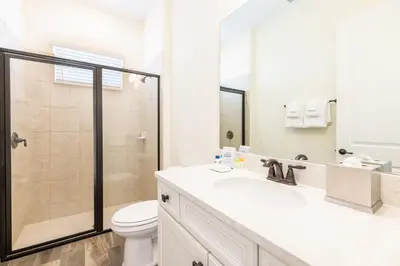 a white bathroom with a toilet and a sink at Mango Breeze Cottage With Private Pool Near Disney With Margaritaville Resort And Island H20 Waterpark Access - 2910Sr in Orlando