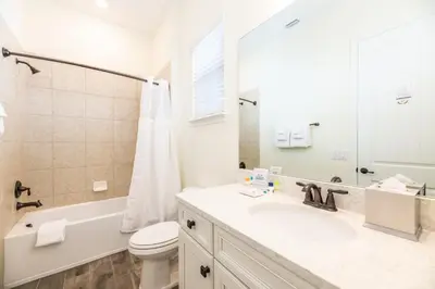 a bathroom with a sink and a toilet and a mirror at Mango Breeze Cottage With Private Pool Near Disney With Margaritaville Resort And Island H20 Waterpark Access - 2910Sr in Orlando