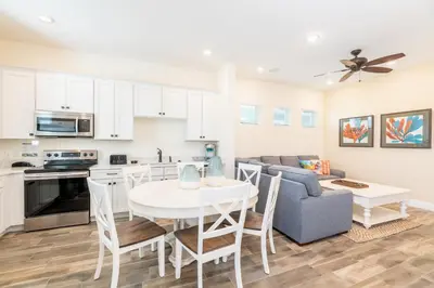 a kitchen and living room with a table and a couch at Mango Breeze Cottage With Private Pool Near Disney With Margaritaville Resort And Island H20 Waterpark Access - 2910Sr in Orlando