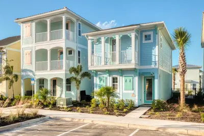 a blue house with palm trees in front of it at Charming Cottage Near Disney With Margaritaville Resort & Island H20 Waterpark Access - 2918Sr in Orlando