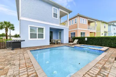 a swimming pool in front of a house at Jamaican Spice Cottage Near Disney With Margaritaville Resort & Island H20 Waterpark Access - 2924Sr in Orlando