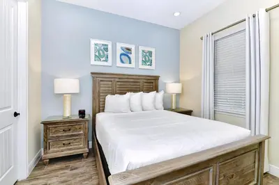 a bedroom with a large bed and two night stands at Jamaican Spice Cottage Near Disney With Margaritaville Resort & Island H20 Waterpark Access - 2924Sr in Orlando