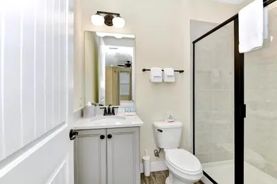 a bathroom with a toilet and a sink and a mirror at Jamaican Spice Cottage Near Disney With Margaritaville Resort & Island H20 Waterpark Access - 2924Sr in Orlando
