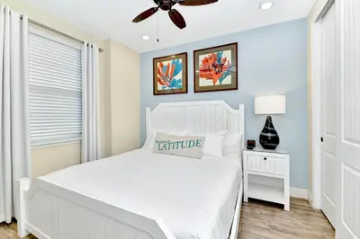 a bedroom with a white bed and a ceiling fan at Jamaican Spice Cottage Near Disney With Margaritaville Resort & Island H20 Waterpark Access - 2924Sr in Orlando