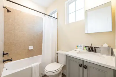a bathroom with a toilet and a sink and a mirror at Cozy Cottage Near Disney With Margaritaville Resort & Island H20 Waterpark Access - 3009La in Orlando
