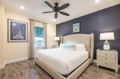 a bedroom with a white bed and a ceiling fan at Cozy Cottage Near Disney With Margaritaville Resort & Island H20 Waterpark Access - 3009La in Orlando