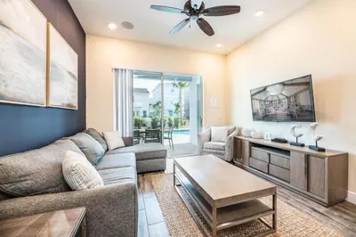 a living room with a couch and a table at The Mermosa Cottage With Private Pool Near Disney With Margaritaville Resort & Island H2O Access - 8016St in Orlando