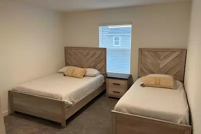 two beds in a small room with a window at Storey Lake home close to Disney and other parks in Kissimmee
