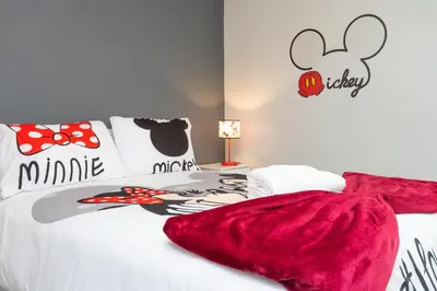 a bedroom with a bed with a red blanket on it at Gorgeous and New House at Le Reve Resort (214221) in Kissimmee