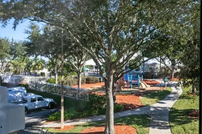 a park with a tree and a playground at Spacious 3 bed, 2 bath Condo in Gated Community condo in Kissimmee