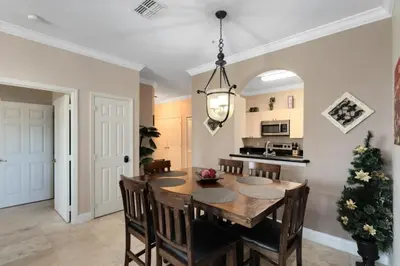 a kitchen and dining room with a wooden table and chairs at Spacious 3 bed, 2 bath Condo in Gated Community condo in Kissimmee