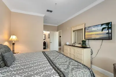 a bedroom with a bed and a flat screen tv at Spacious 3 bed, 2 bath Condo in Gated Community condo in Kissimmee