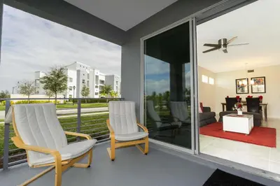two chairs and a table on a patio with glass doors at Gorgeous 3Bd 8 Guests @Storey Lake Resort Close to Disney 101 3191 in Kissimmee