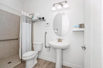 a bathroom with a toilet and a sink and a mirror at Beautiful Cottage Near Disney With Margaritaville Resort & Island H2O Access - 3029La in Orlando
