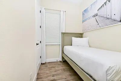 a small bedroom with a bed and a window at Inviting Cottage With Private Pool Near Disney With Margaritaville Resort & Island H2O Access - 8022Kd in Orlando